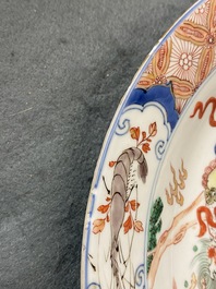Un plat en porcelaine de Chine famille verte &agrave; d&eacute;cor d'une carpe entour&eacute;e de chevaux et lions bouddhistes, Kangxi